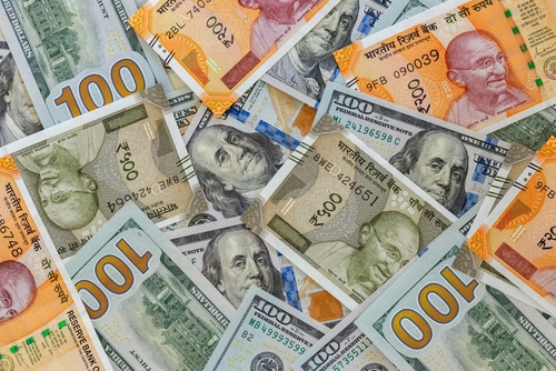 U.S. dollars and Indian rupee banknotes arranged together.